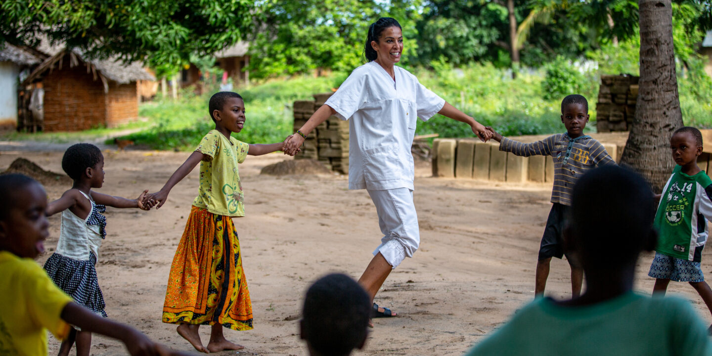 Student holding hands with children