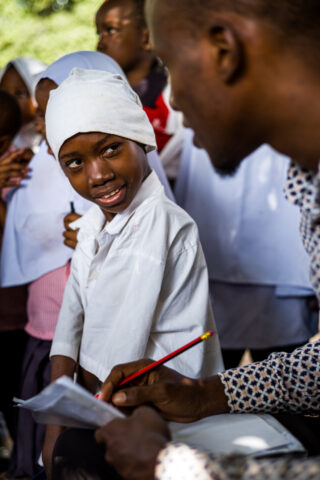 Man taking notes while speaking with a child