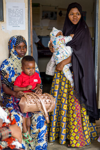 Two women with each their child, one in lap, and one held