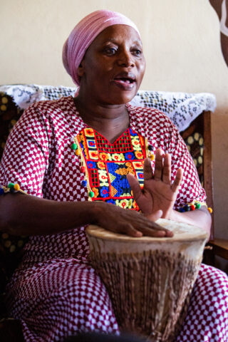 Woman singing and playing drums in a song session in the family home