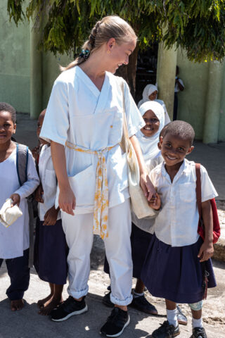 Student holding the hand of a child