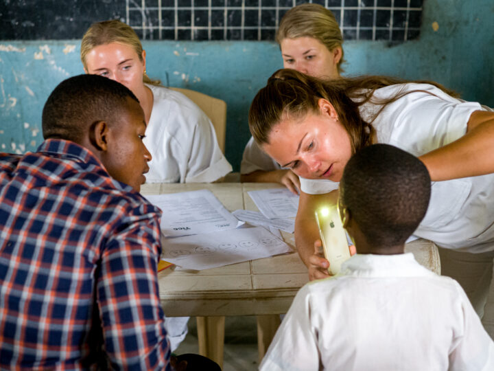 Student inspecting a childs teeth