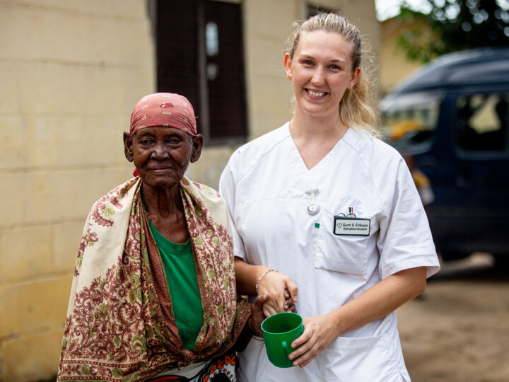 Student holding hands with a resident of the elderly home